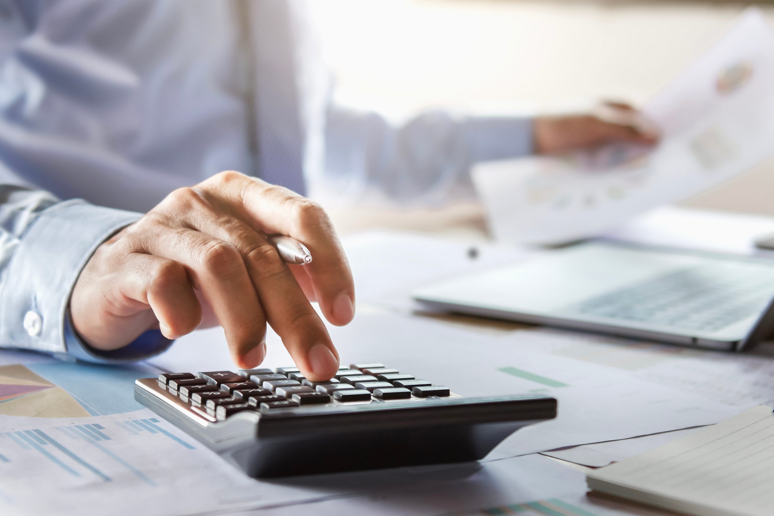 accountant working on desk using calculator for calculate financ